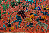 Wat Xieng Thong temple in Luang Prabang, Laos. the Ho Tai, the library. Colourful glass mosaics on a pink background with scenes of daily life. 